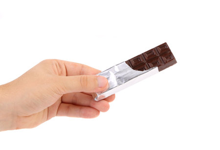 Hand holds bar of chocolate in foil. White background.