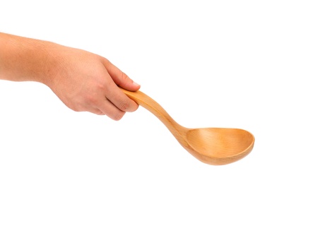 Hand holds wooden spoon. Isolated on a white background.の写真素材