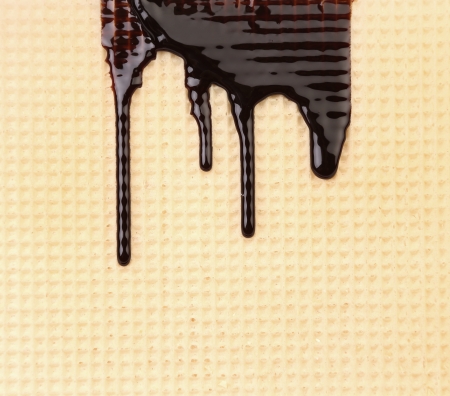 Melted chocolate dripping on waffle. Isolated on a white background.の写真素材