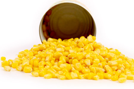 Opened cans and pilr of corn. Isolated on a white background.の写真素材