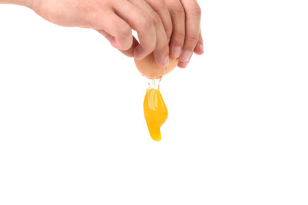 Closeup of broken egg in hand. Isolated on a white backgroundの写真素材