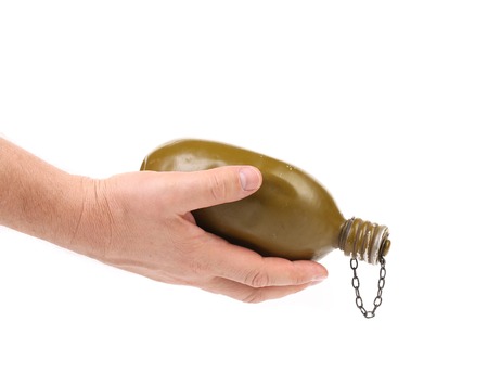 Hand holds old army canteen. Isolated on a white backgroundの写真素材