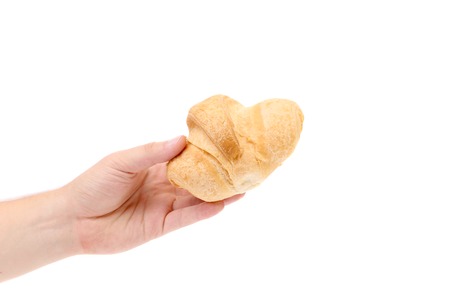 Hand holds striped fresh croissant. Isolated on a white background.の写真素材