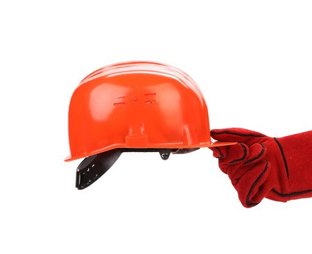 Hand in leather gloves holds hard hat. Isolated on a white backgropund.の写真素材
