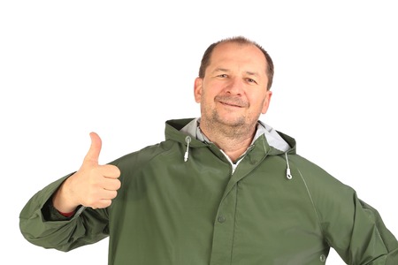 Man in coat shows thumb up. Isolated on a white background.の写真素材