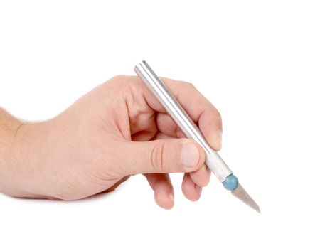 Hand holds aluminium Craft Knife on a white backgroundの写真素材