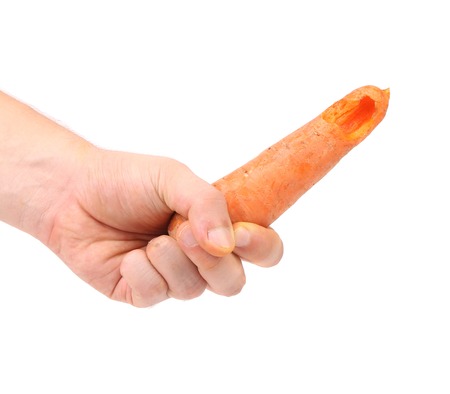 Hand holds fresh carrot. Isolated on a white backgroundの写真素材
