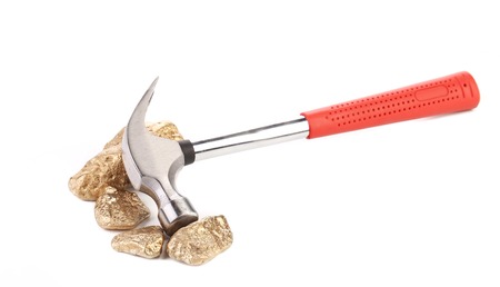 Closeup of metal hammer with gold nuggets. Isolated on a white background.の写真素材