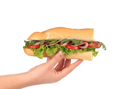 Half of french baguette sandwich in hand. Isolated on a white background.の写真素材