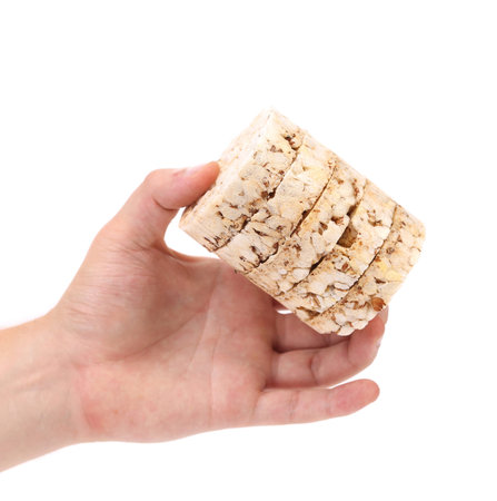 Puffed rice snack in hand. Isolated on a white background.