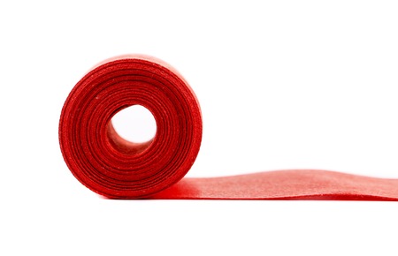 Red silk ribbon roll. Isolated on a white background.の写真素材