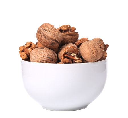 Close up of walnuts bunch in bowl. Isolated on a white background.