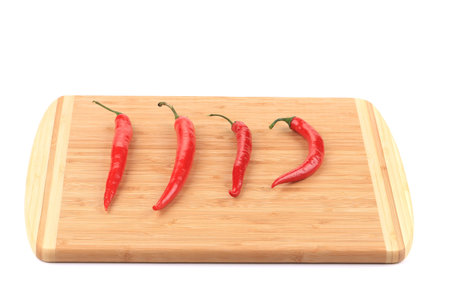 Spicy pepper on cutting board. Isolated on a white .