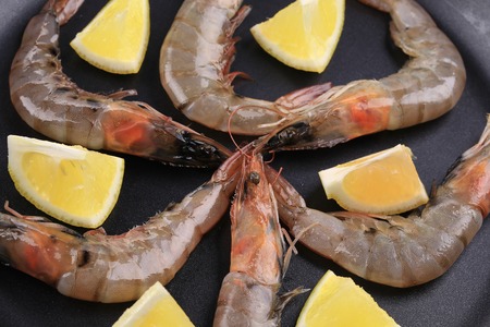 Raw shrimps on pan with lemon. Whole background.の写真素材