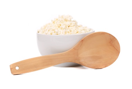 Cottage cheese in bowl with spoon. Isolated on a white background.の写真素材