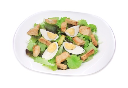 Close up of caesar salad with eggs. Isolated on a white .の写真素材