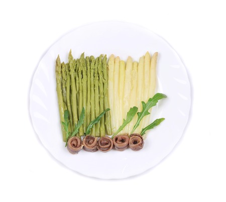 White and green asparagus with anchovies. On a white plate.の写真素材