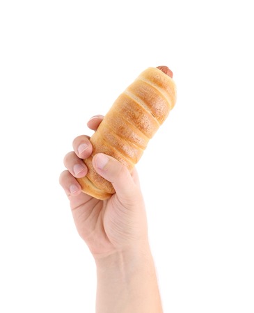 Hand holds baked hot dog. Isolated on a white background.の写真素材