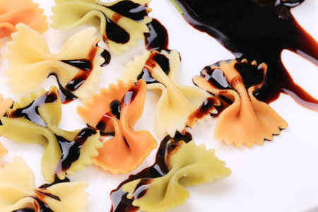 Bow tie pasta with soy sauce. Isolated on a white background.