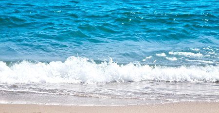 Beautiful ocean surf and white foam near coast.