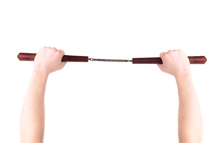 Hands hold martial arts nunchaku. Isolated on a white background.の写真素材