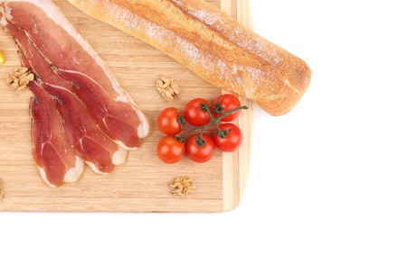 Prosciutto with tomatoes on wooden platter. の写真素材