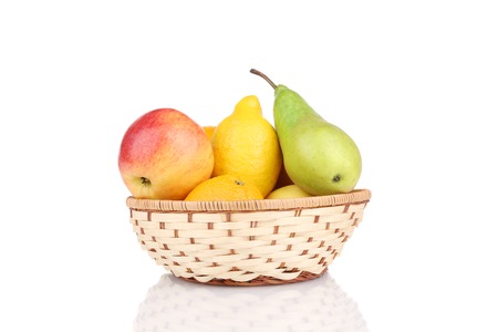 Wicker basket full of juicy fruits. Isolated on a white background.の写真素材