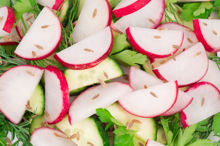 Tasty radish salad with cucumbers and parsley. Isolated on a white background.の写真素材