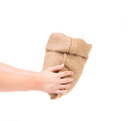 Hand holds bag of money. Isolated on a white background.の写真素材