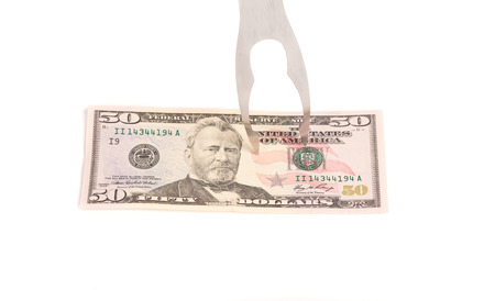 Bbq fork touching fifty dollar bill. Isolated on a white background.の写真素材