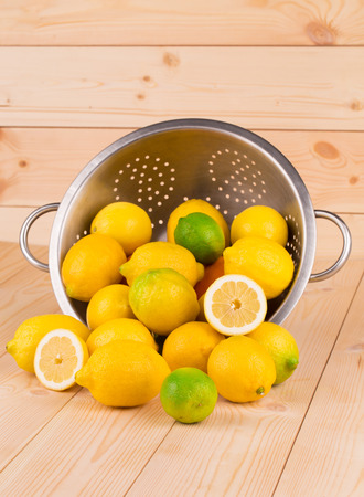 Citrus fruits in colander on wood. Whole background.の写真素材