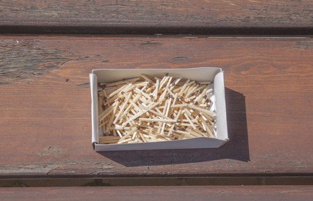 Pile of matchsticks in the box on a wooden bench. Close up.の写真素材