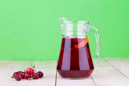Pitcher with cherries and juice, isolated on a white backgroundの写真素材