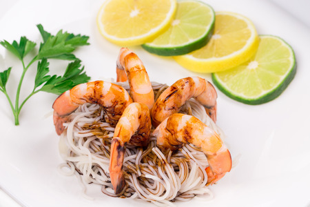 tiger shrimps with pasta on a plate isolatedの写真素材