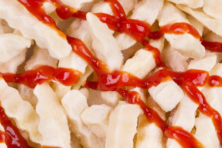 Background of ketchup and frozen potatoes. Close up.