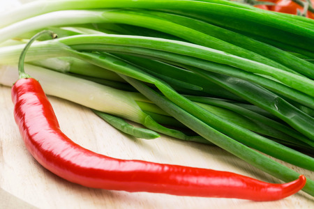 Bunch of green onion with red pepper. Isolated on a white background.の写真素材