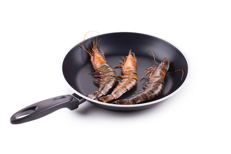Tiger shrimps on black pan. Isolated on a white background.の写真素材