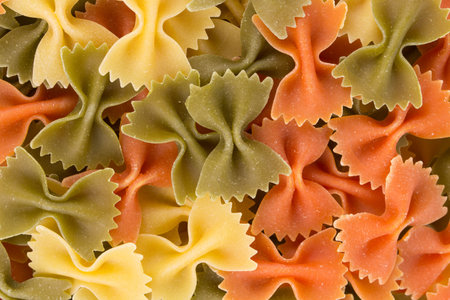 Bunch of the farfalle pasta three colors. Whole background.の写真素材