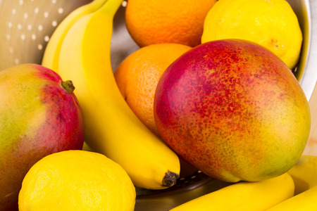 Citrus fruits with mango on wooden background close upの写真素材