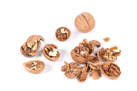 Heap of cracked walnuts. Isolated on a white background.