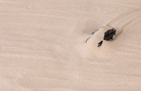 Concept of black racing car on the sand. Close up.