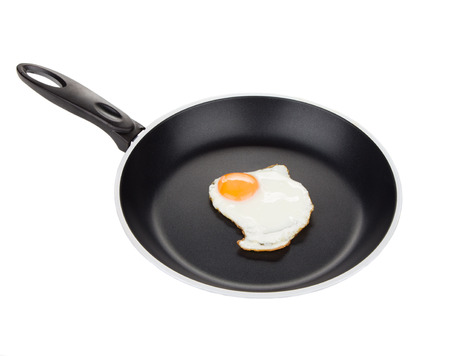 Fried egg in a frying pan isolated on a white background closeupの写真素材