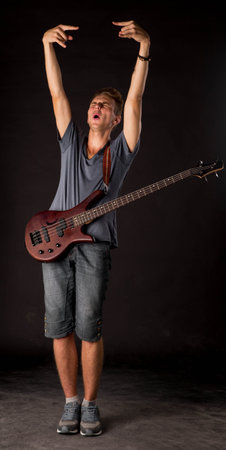 Bass guitarist. Located on the black background.