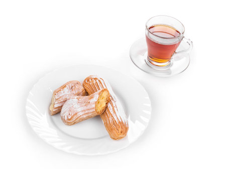 Cup of tea with eclairs isolated on a white closeup