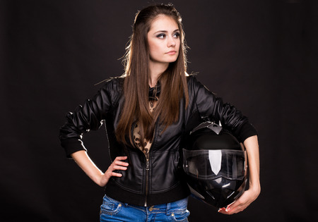 Fashion model woman with motorbike helmet on the black background.の写真素材