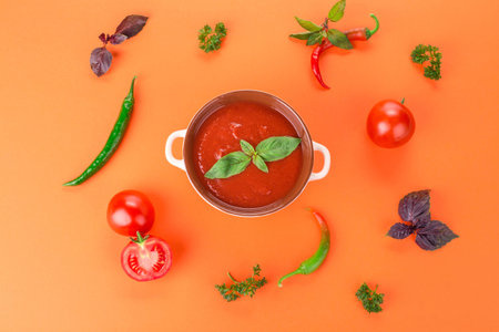 Bowl of tomato soup with basil. Whole background.