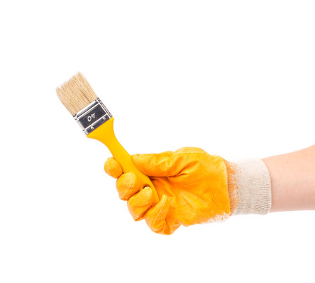 Hand in glove holds brush. Located on a white background.の写真素材