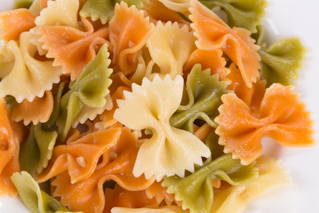 Bunch of the farfalle pasta three colors. Whole background.の写真素材