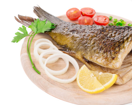 Fried carp tail with lemon and onion. Whole background.