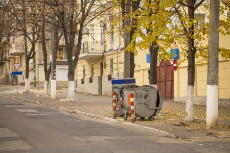 Curbside recycling bins in old downtown, empty street in autumnの写真素材